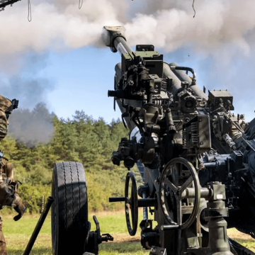 soldier covering ears firing m777 howitzer